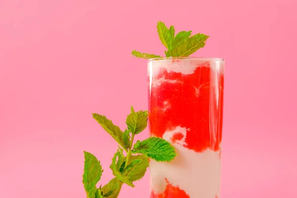 Truskawkowy koktajl i śmietana w przezroczystym kielichu z truskawkami i gałązkami mięty na różowym tle. Letnie koktajle i napoje. — Zdjęcie stockowe