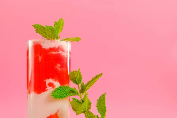 Bevande estive. Cocktail di fragole. Frullati di bacche. Cocktail rosa e crema in un calice trasparente con fragole e rametti di menta su fondo rosa. — Foto Stock