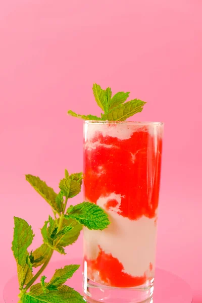 Berry smoothies.Strawberry cocktail. Pink cocktail and cream in a transparent goblet with strawberries and sprigs of mint on a pink background. Summer cocktails and drinks. — ストック写真