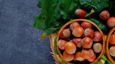 Hazelnuts with green leaves close-up on a wooden saw cut