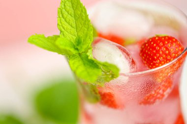Çilekli içecek. İçecekler. Tazeleyici kokteyl. Buzlu ve çilekli bardakta su. Buzlu ve çilekli maden suyu.