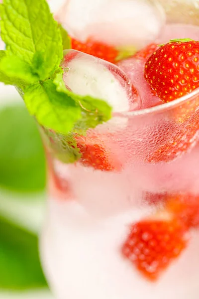 Bebida de fresa.Cóctel refrescante. agua en vaso con hielo y fresas. Agua mineral con hielo y fresas en una copa de vidrio y fresas maduras con hojas. —  Fotos de Stock