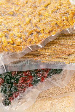 Ürünlerin depolanması vakumlu poşetlerde. Yiyecek tedariği. Uzun depolama ürünleri. Erzak, tahıl, makarna, fındık ve meyve paketleri. pirinç, erişte, kuru meyve yığını.