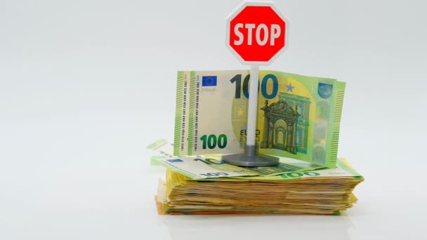 Zatrzymanie inflacji pieniądza euro. Odmowa zapłaty w euro Banknoty euro i czerwony znak stopu na białym tle. Spadek i amortyzacja waluty euro. — Wideo stockowe