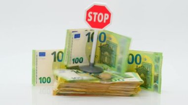 Euro para enflasyonu. Para biriminde düşüş ve değer kaybı. Euro para birimini durdur. Avro banknotları, düşen avro paraları ve beyaz arka planda kırmızı dur işareti