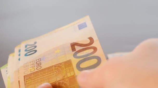 Banknoty euro w rękach.Przeliczanie pieniędzy. Waluta euro. Pieniądze w rękach na rozmazanym szarym tle. — Wideo stockowe