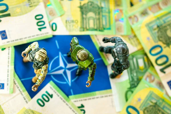 Militärausgaben der NATO-Länder. Militäretat der NATO-Länder. Militärfiguren in NATO-Flagge und Euro-Banknoten. Militärfinanzierung der NATO — Stockfoto