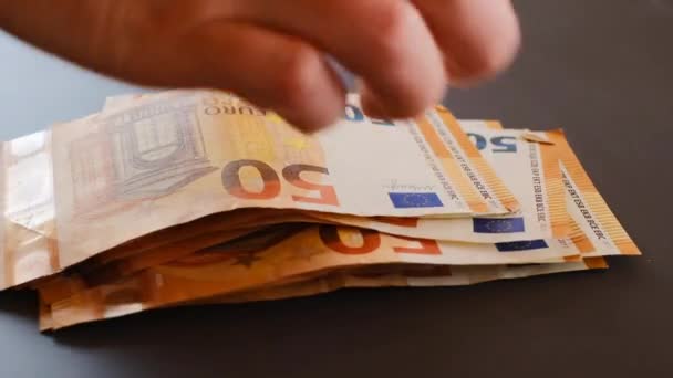 Ricalcolo di denaro.mani contare le banconote in euro su sfondo grigio. confezioni da cinquanta euro. Banconote in euro in mano primo piano. Soldi in mano — Video Stock