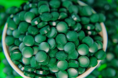 Yuvarlak bir kaseye, alg hapları koymuşlar. Vitaminler ve beslenme takviyeleri. Daha besleyici yiyecekler. Sağlıklı bir yaşam tarzı için gıda takviyeleri.