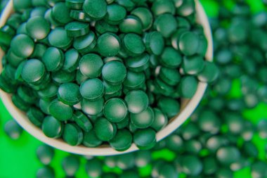 - Kasede bir çeşit ilaç var. Yeşil arka planda spirulina tabletleri. Vitaminler ve beslenme takviyeleri. Daha besleyici yiyecekler. Sağlıklı bir yaşam tarzı için gıda takviyeleri.