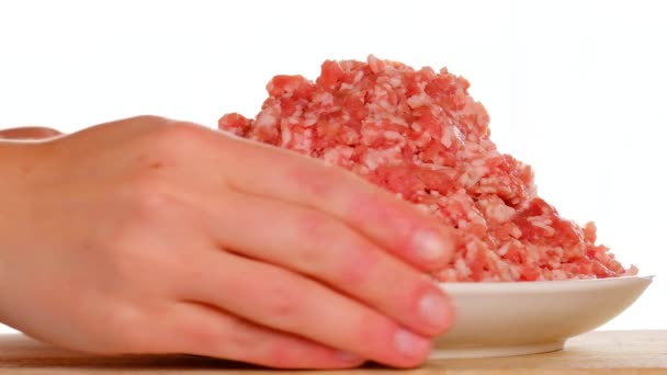 Surowa mielona wieprzowina w białej ceramicznej filiżance, ręce są pobierane ze stołu na białym tle.Mięso products.Farm ekologiczne bio mięso. — Wideo stockowe