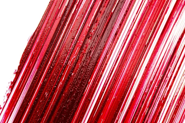 Kırmızı ruj makrosu. Beyaz arka planda ruj dokusu. Kırmızı ruj yüzeyi. Ruj arka planı. Makyaj ve kozmetik ürünleri.