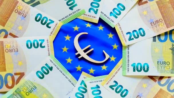 Växelkurs i euro. eurosedlar och eurotecken på Europeiska unionens flagga. Rotation.Avskrivning av eurovalutan. — Stockvideo