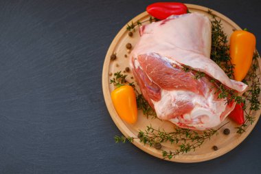 Kemikte domuz eti, taze biber ve tahta tahtada kekik otu. Siyah bir arka planda. Et ürünleri. Çiftlik organik eti..