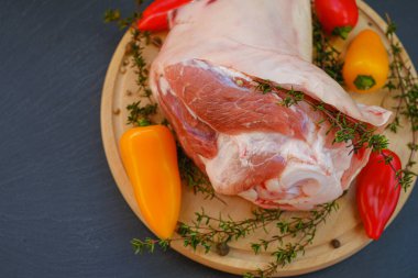 Kemikte domuz eti, taze biber ve tahta bir tahta üzerinde kekik. Arka planda et ürünleri..