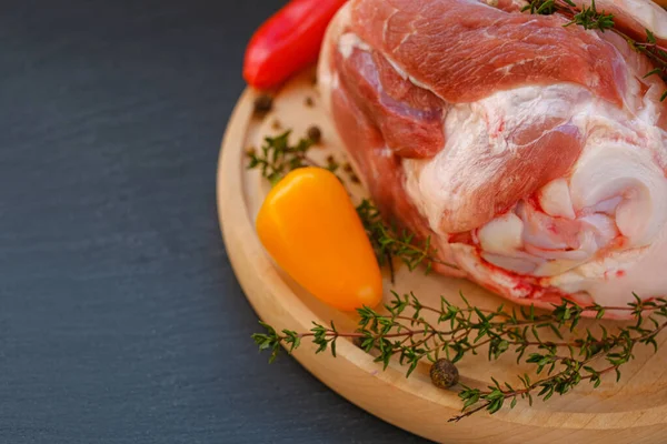 Kemikte domuz eti, tatlı biber ve tahta tahtada kekik otu. Siyah bir arkaplanda. Et ürünleri. Çiftlik organik eti..