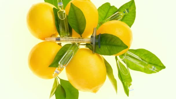 Vitamine C in ampullen. Citroenen en transparante ampullen. Injecties met vitamine C, citroenen fruit met groene bladeren. Schoonheid en gezondheid. — Stockvideo