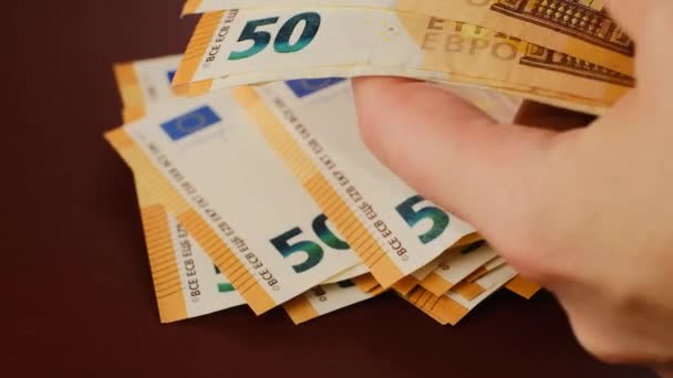 Opakowanie banknotów 50 euro. wydatki i dochody w krajach europejskich. rozdań liczyć rachunki na brązowym tle.Podział budżetu.Pieniądze w rękach.Przeliczenie pieniędzy.Kurs walutowy euro — Wideo stockowe