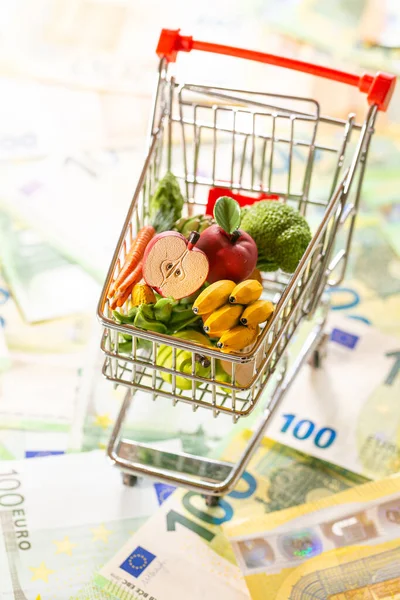 Stijgende voedselprijzen in de Europese Unie.Voedselprijzen in Europa. supermarkt trolley met boodschappen op eurobankbiljetten achtergrond.Levensmiddelenmand in Europa. voedselcrisis. — Stockfoto
