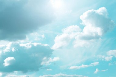 Sky.Bulutlar ve güneş. Açık mavi bir gökyüzünde beyaz bulutlar ve güneş ışınları. Mavi tonlarda güzel cennet duvar kağıtları. Cennet arkaplanı.