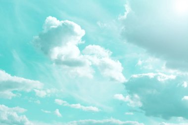 Sky.Bulutlar ve güneş. Açık mavi bir gökyüzünde beyaz bulutlar ve güneş ışınları. Mavi tonlarda güzel ilahi duvar kağıtları. Gökyüzü çok açık renkli. Cennet arkaplanı.