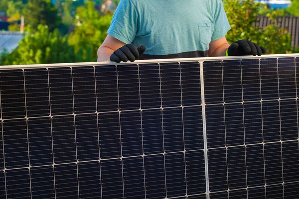 Green energy. Solar panel in the hands of a worker in a summer garden. Fitting and installation of solar panels.renewable energy.alternative energy from nature.solar power technology.