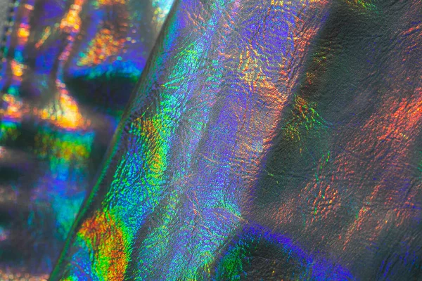 Mor ve yeşil renkli holografik duvar kağıdı. Yanardöner dalgalar ve kıvrımlı doku. Güzel metalik parlak kumaş. Soyut trend holografik arka plan. Metal holografik materyal.