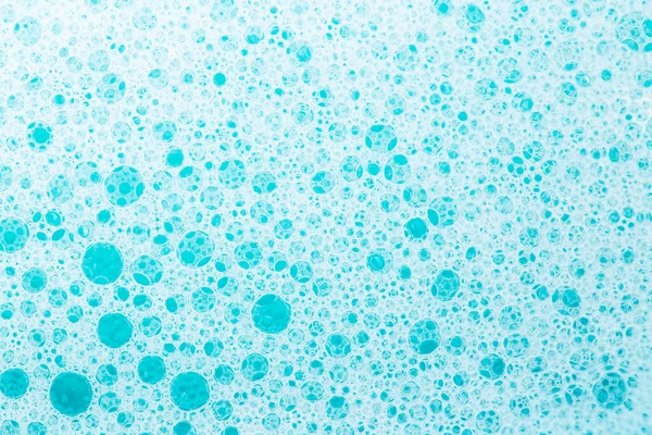 Foam Water Soap Suds.Texture Foam Close-up. blue soap bubbles background.Laundry and cleaning background.foam bubbles.Blue water with white foam bubbles.Cleanliness and hygiene background.