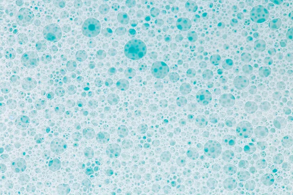 Blue water with white foam bubbles.Cleanliness and hygiene background.foam bubbles. Foam Water Soap Suds.Texture Foam Close-up. blue soap bubbles background.