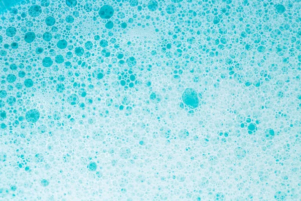 foam bubbles.Blue water with white foam bubbles.Cleanliness and hygiene background. Foam Water Soap Suds.Texture Foam . blue soap bubbles background.