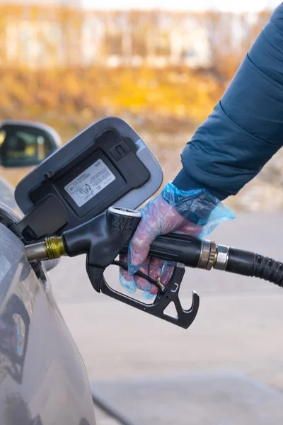 Fuel price in Europe. Refueling the car.Refueling pistol in the hands of a man .Car at a gas station. Silver car, refueling pistols and gloves.man fills up a car tank with diesel fuel.