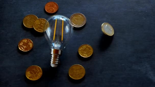 欧洲电价上涨节电黑粉笔木板上的灯泡和欧元硬币欧盟国家的能源生产危机增加光价 — 图库视频影像