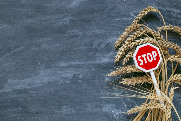 Wheat import and export ban.Rising prices for wheat and flour products.Stop on the import and export of wheat.Wheat ears and red stop sign on black chalk board background.World food shortage