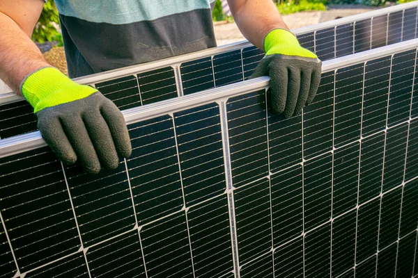 Smart consumption and energy saving. Solar panel in the hands of a worker.solar power technology. Fitting and installation of solar panels.Green energy.alternative energy from nature.