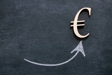 Euro growth. Rise in the euro exchange rate.growth of the exchange rate.Euro currency status.Euro sign and up arrow on black chalk board background.Economic stability 