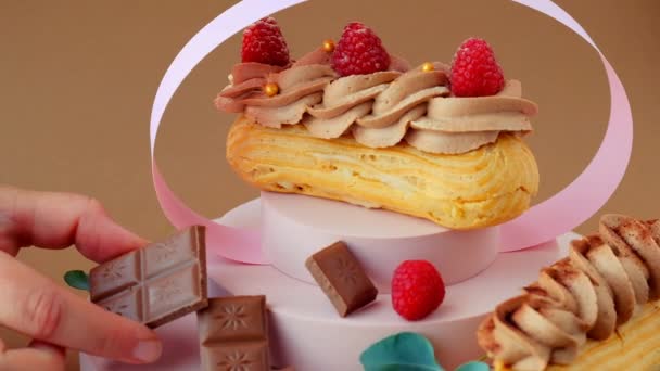 Eclairs Cakes Eclair Custard Cakes Chocolate Cream Raspberries Pink Podium — Vídeo de stock