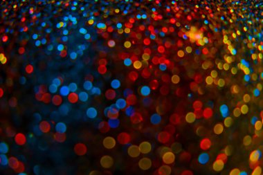Shiny Festive Background. Lots of Flashing colorful spots.colorful bokeh background. Multicolored garlands on a black background. Christmas background. Glowing bokeh.soft focus.