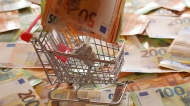 Rising electricity prices in Europe. Light bulb in a shopping cart,euro bills on euro banknotes background.Electricity cost. Crisis of energy production in the EU countries