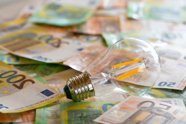  light bulbs on euro bills.Electricity cost.Rising electricity prices in Europe. Crisis of energy production in the EU countries.Saving electricity concept
