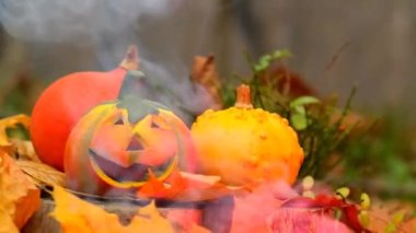 Burning Jack lantern in autumn forest.Pumpkin on sparks and smoke background. 4k footage