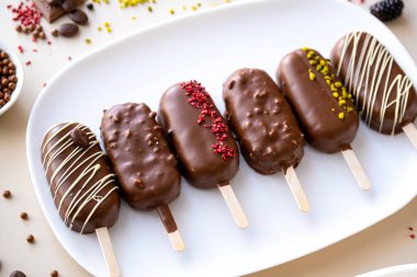 cupcake ice cream with chocolate cream.Choux pastry. Chocolate cupcakes set on a white plate.Chocolate biscuits on a stick in the form of ice cream.Appetizing cupcakes and pastries. 