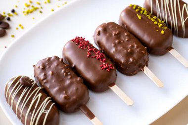 biscuits on a stick in the form of ice cream.Appetizing cupcakes and pastries. cupcake ice cream with chocolate cream.Choux pastry. Chocolate cupcakes set on a white plate.