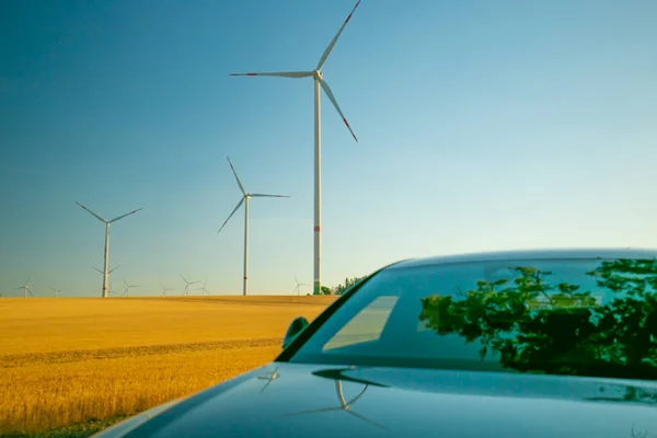 Wind generators and car in the field .Alternative energy for cars.Refueling the car with natural renewable resources