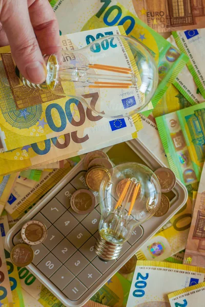 Paying electricity bills in Europe.Electric light bulb on euro bills background. Rising electricity prices. Payment for utility services.Energy production crisis in European countries.