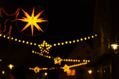 Noel kenti aydınlığı. Avrupa Noel sokaklarının parlak çelenkleri. Almanya 'da kış tatili. Işıl ışıl parıldayan altın çelenklerle karanlık bir arka plan. Gece aydınlatması.