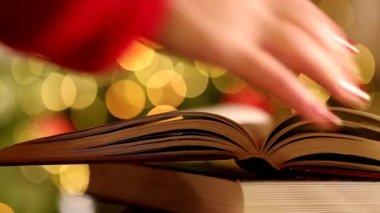 Noel ve kış temalarıyla ilgili kitaplar. El kitabın sayfalarını çeviriyor. 4k görüntü