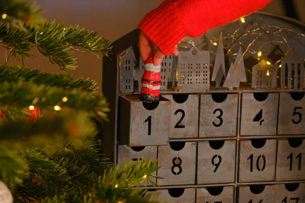 在圣诞节来临的日历背景上 手拿着巧克力圣塔爪 圣诞节的传统和象征 圣诞和新年的礼物和惊喜 — 图库照片