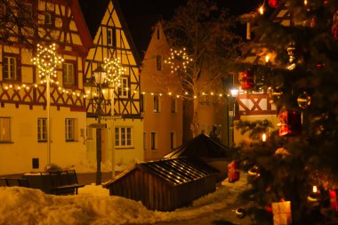 Almanya 'da Noel' de, yarı ahşap evler ve parıldayan süslemeler. Avrupa Noel sokaklarının parlak çelenkleri. Işıldayan altın çelenklerle dolu karanlık bir arka plan..