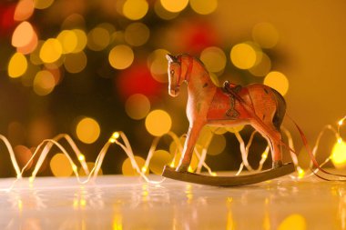 Noel ve Yeni Yıl geçmişi. Parlak çelenklerle süslenmiş tahta at. Sıcak renklerde. Keyifli bir ortam. Eski usul Noel ağacı oyuncakları