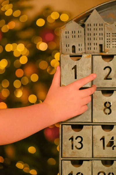 金属日历和小孩手拉手靠近圣诞树 玩具在模糊的房间背景上闪闪发光的花环 圣诞传统和象征 新年礼物和惊喜 — 图库照片
